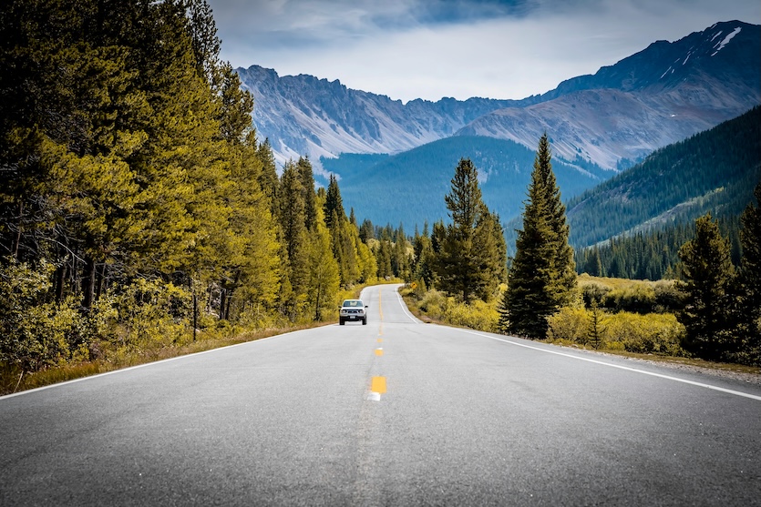 Mountain road near Walden in Jackson County, Colorado surrounded by pines and high country mountains.